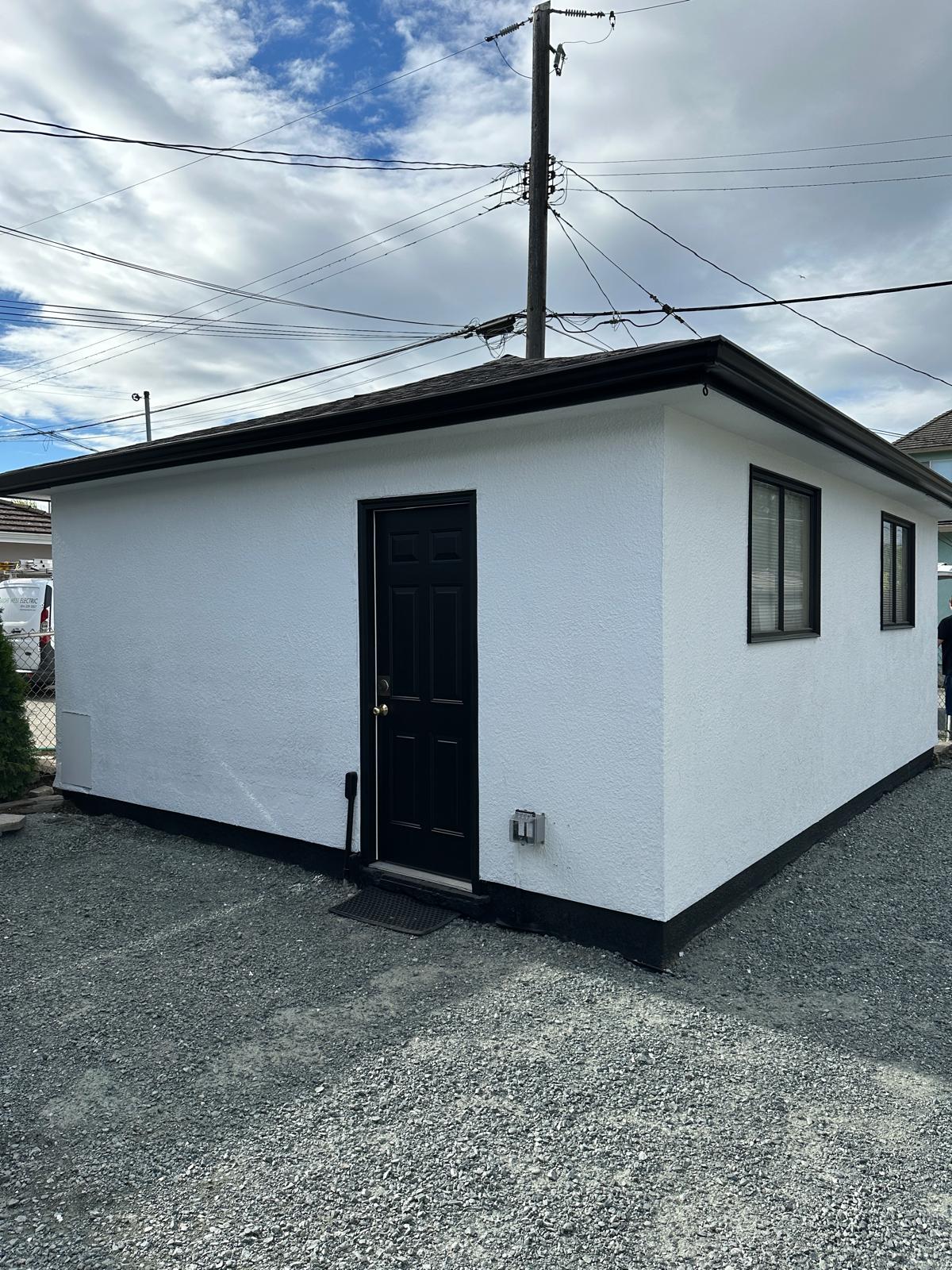 An outbuilding painted pale grey