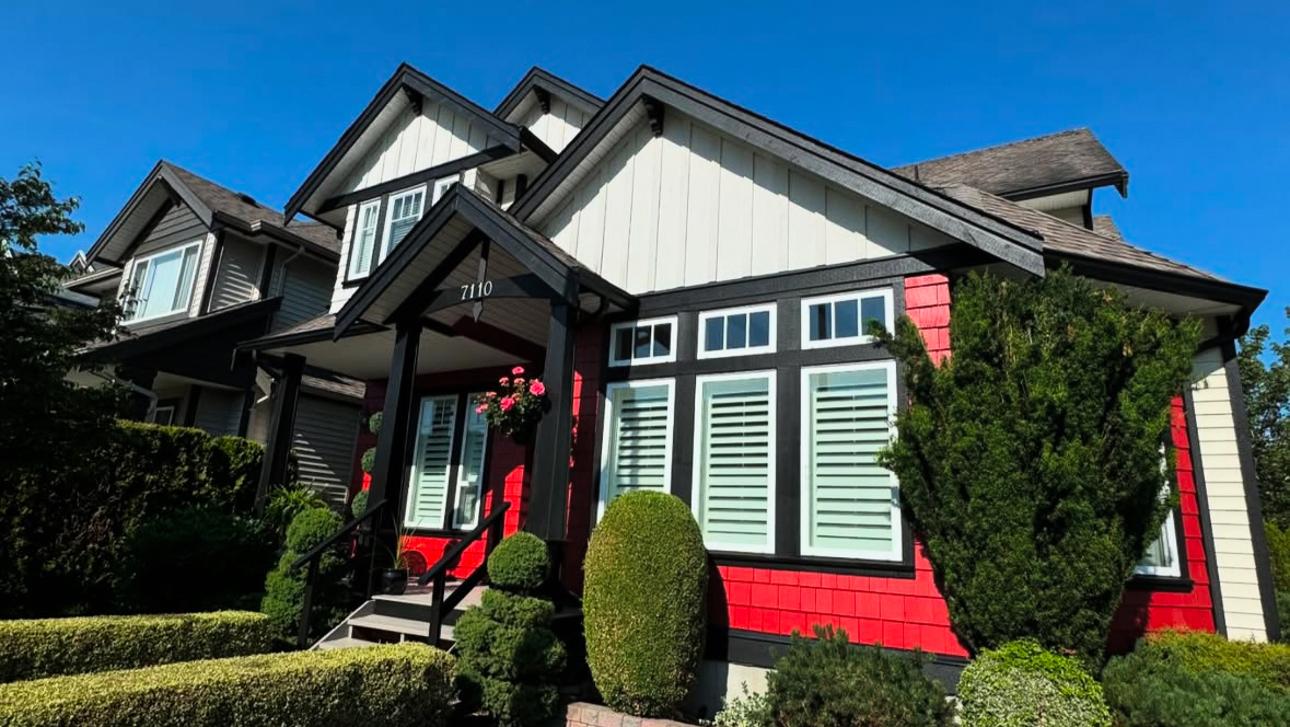 A dark painted home with a red door